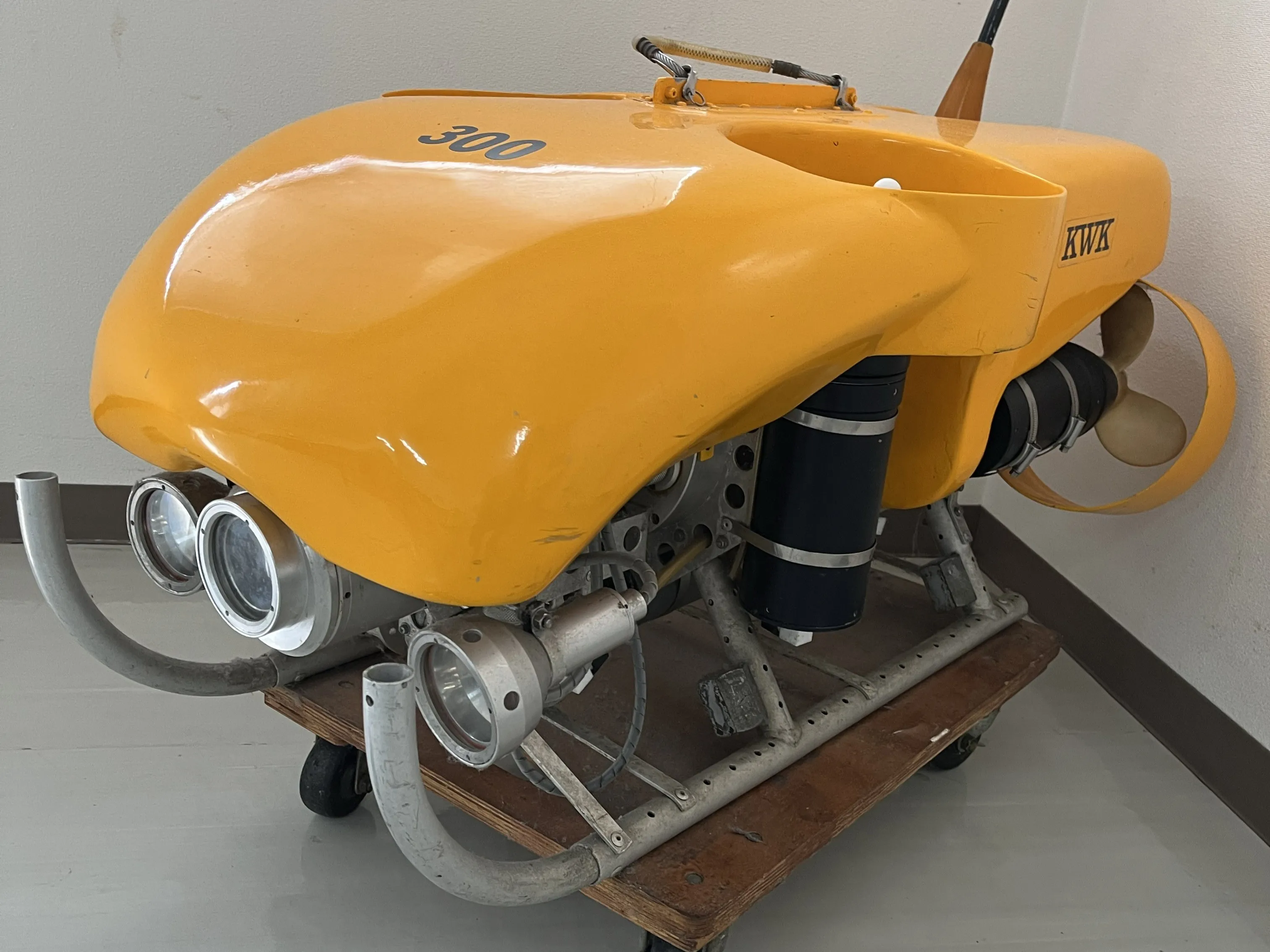 黄色い水中探査機ROVの機体。前面にライト2灯を備え置かれている様子