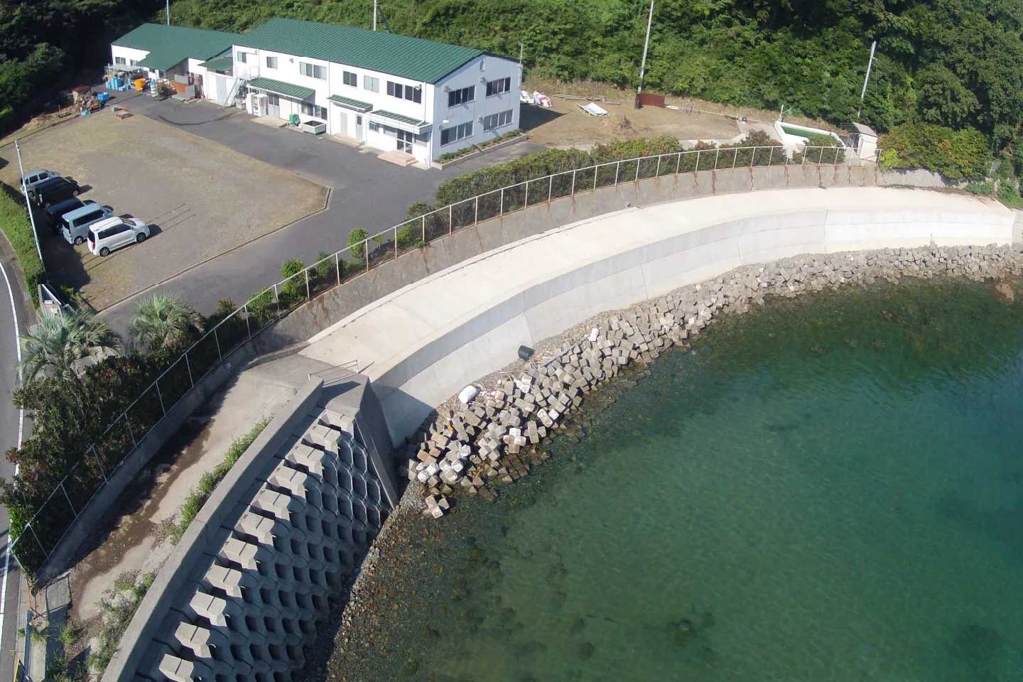 和歌山県の広川工場を上空から見た様子。手前に青緑の海、背景に緑の丘陵